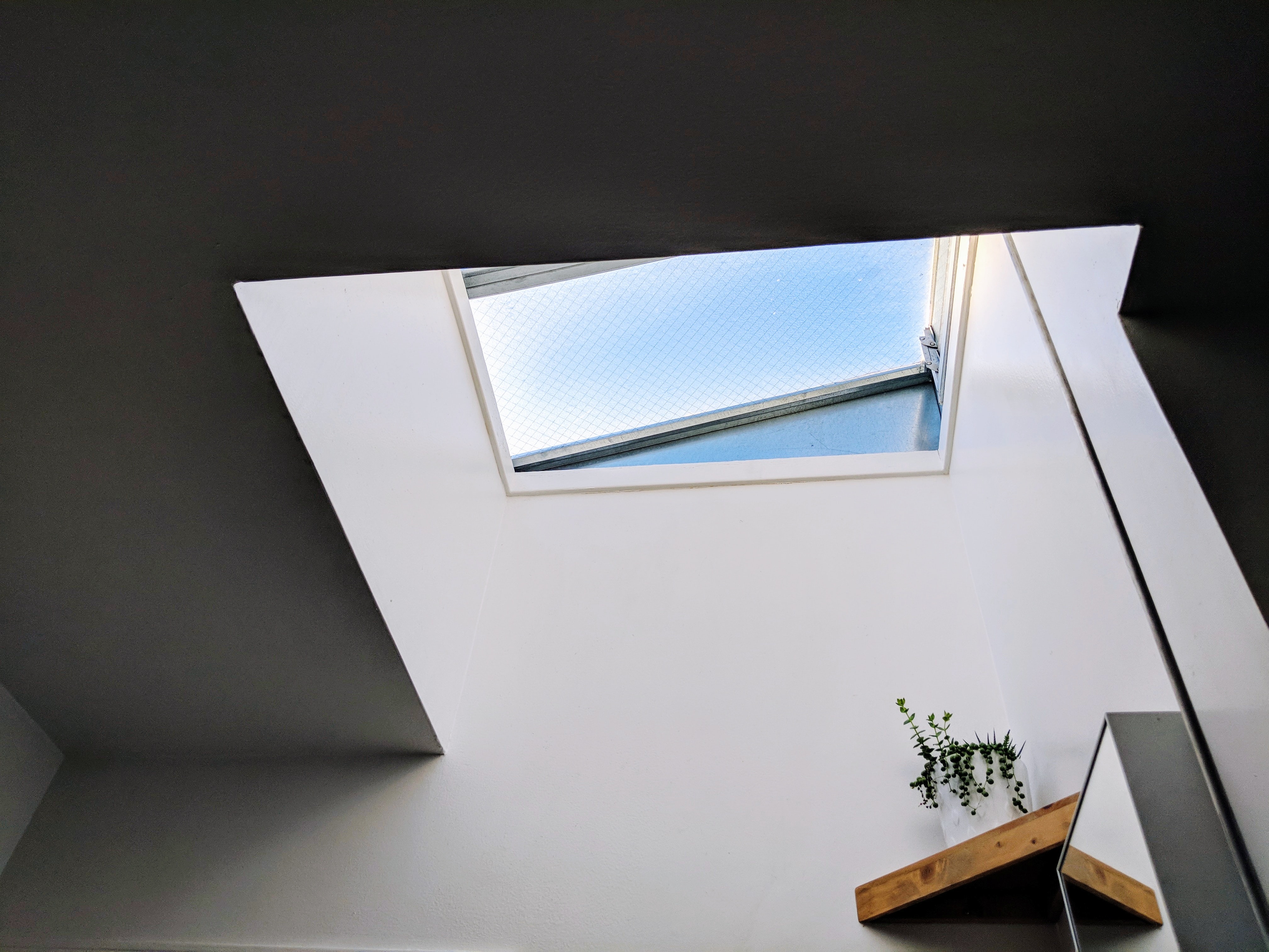 A white wall below a skylight window