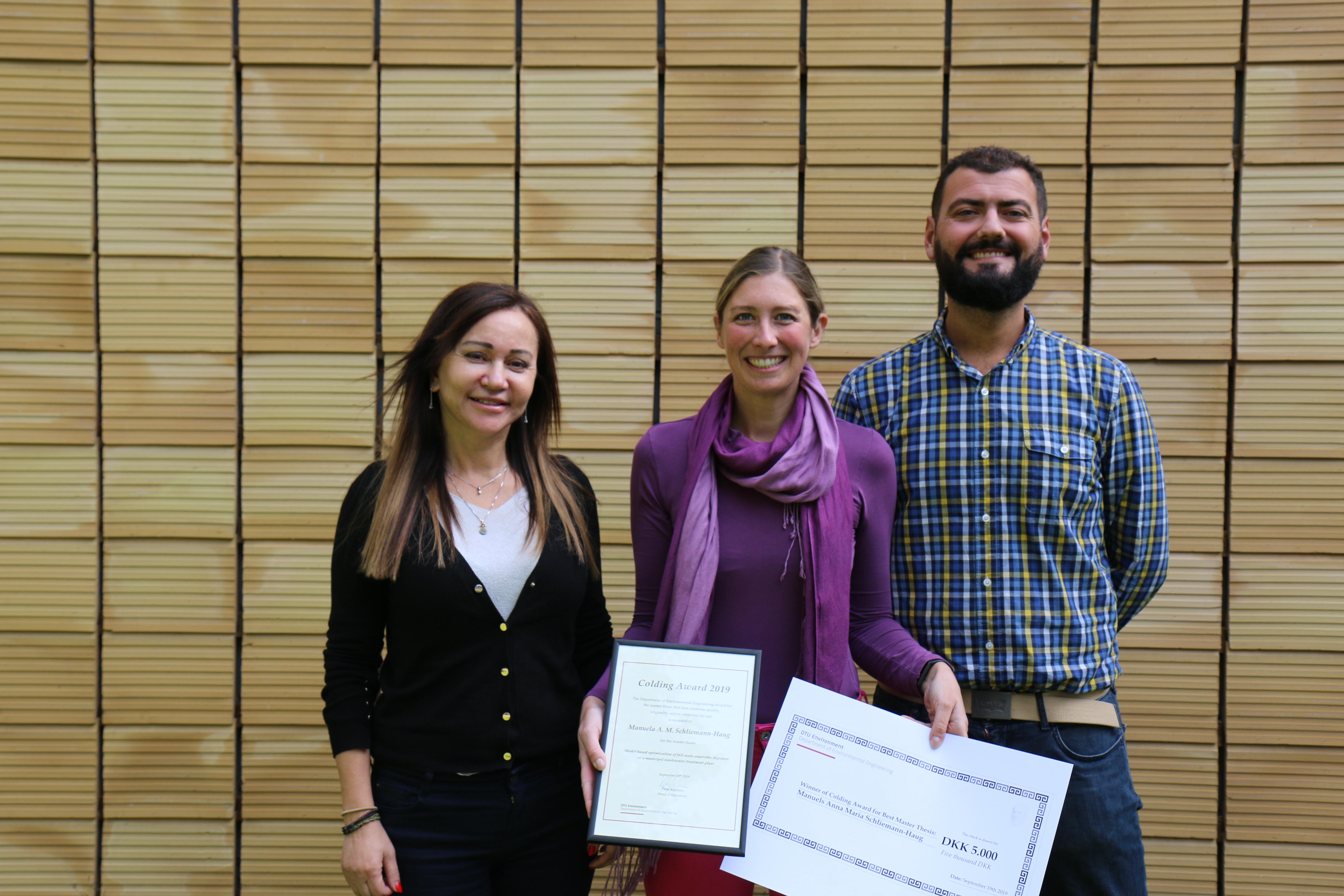 Winners of the DTU Sustain Colding Award 2019 standing in front of yellow coloured tiles